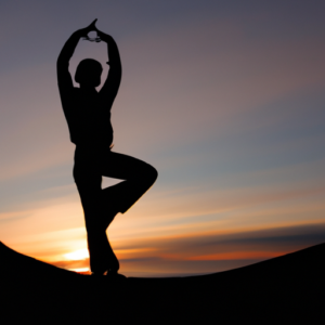 A silhouette of a person in a yoga pose overlooking a sunrise.
