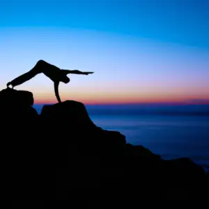 A silhouetted figure performing a difficult yoga pose on the edge of a cliff overlooking a sunrise.