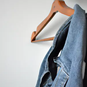 Suggested Prompt: Light blue denim fabric draped over a wooden hanger.