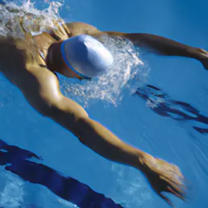 A swimmer in mid-stroke, viewed from the side, in a pool with sun reflecting off the surface.