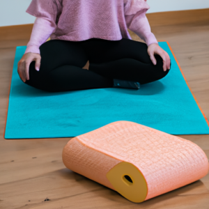 A person sitting in a lotus position in a yoga studio with a yoga mat and meditation cushion.