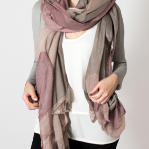 A woman wearing a casual scarf with a neutral color palette.
