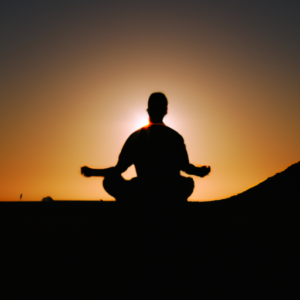 A silhouette of a person in a meditative pose in front of a rising sun.