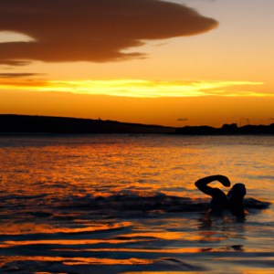 A swimmer silhouetted against a sunset at the beach.