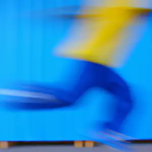 A blurred image of a person jumping with bright blue and yellow streaks in the background.