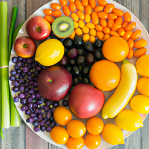 A plate of colorful fruits and vegetables arranged in a rainbow pattern.
