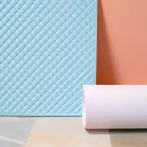 A white yoga mat draped over a pastel-colored yoga block.